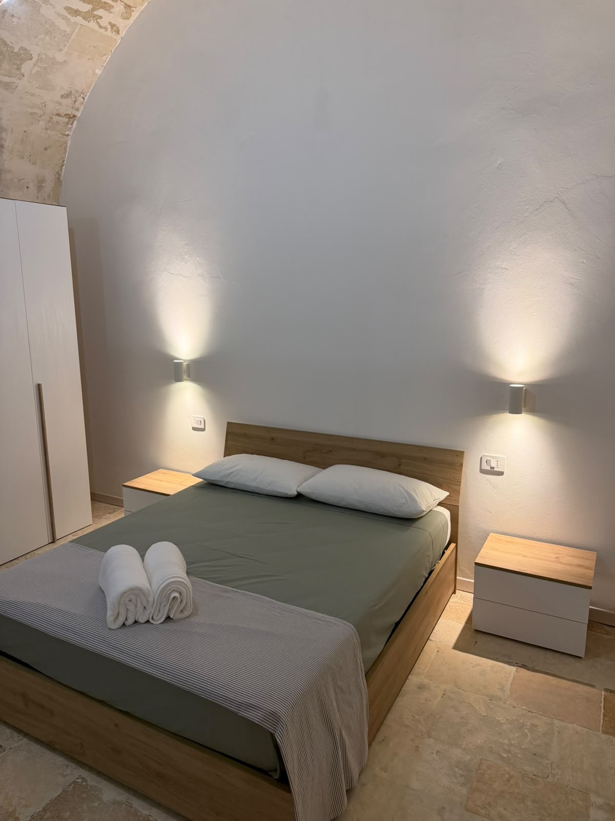 Letto matrimoniale con luci soffuse alle pareti